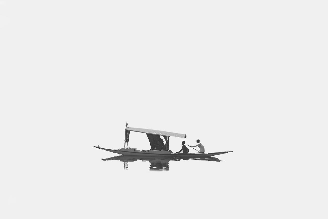 Minimalist black and white photo of a shikara on Dal Lake capturing serene moments.